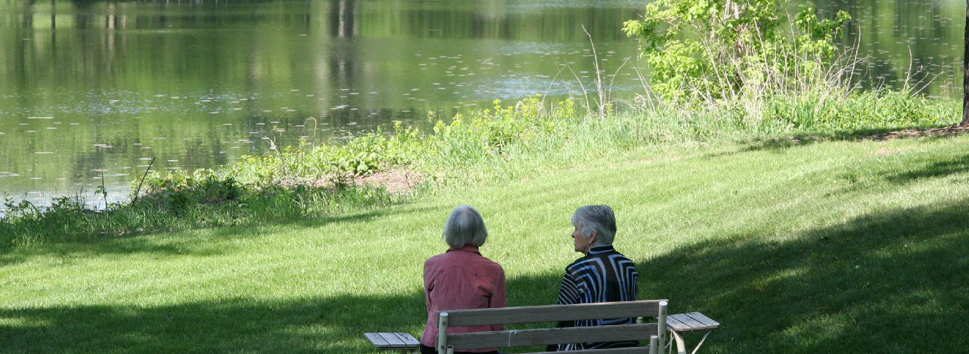 two residents on bench on the shore