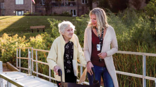 Elim Shores resident and caregiver enjoy a meaningful walk along the community’s walking path.