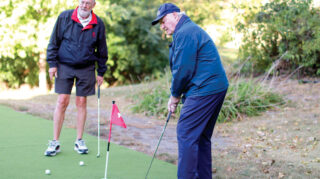 Elim Shores residents enjoy a sunny day at the backyard golf course, living active and joyful lives.